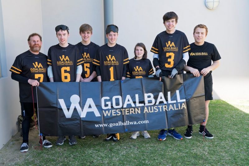 Team members of Goalball hold banner which reads Goalball Western Australia