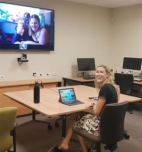 Speech Therapist Monique sits in a large room with a laptop in front of her, client in bigger screen directly in front of her." width="299" height="319" /> Speech Therapist Monique Ziegelaar conducting an online therapy session