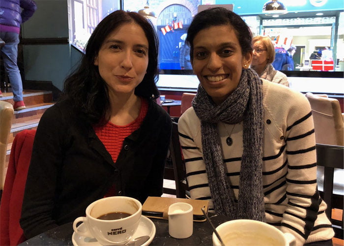 Dr Mariana Lopez and Vithya Vijayakumare sitting in a coffee shop.