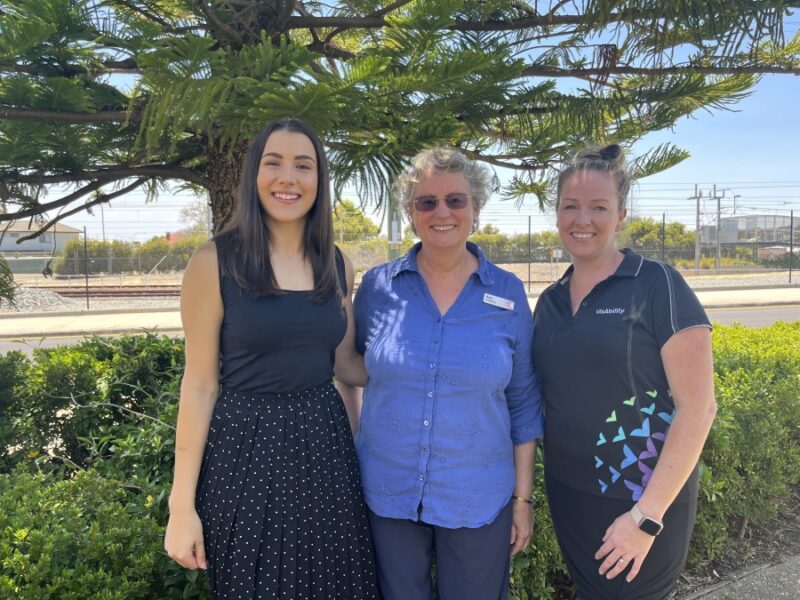 Helena, Ruth and Laura stand next to each other with green trees behind them 