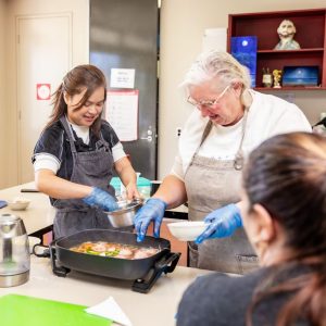 CAC team member and client cooking together in the community centre